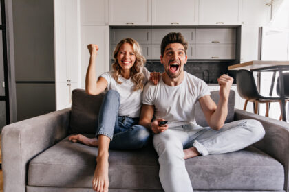 a couple sitting on a couch and watching tv